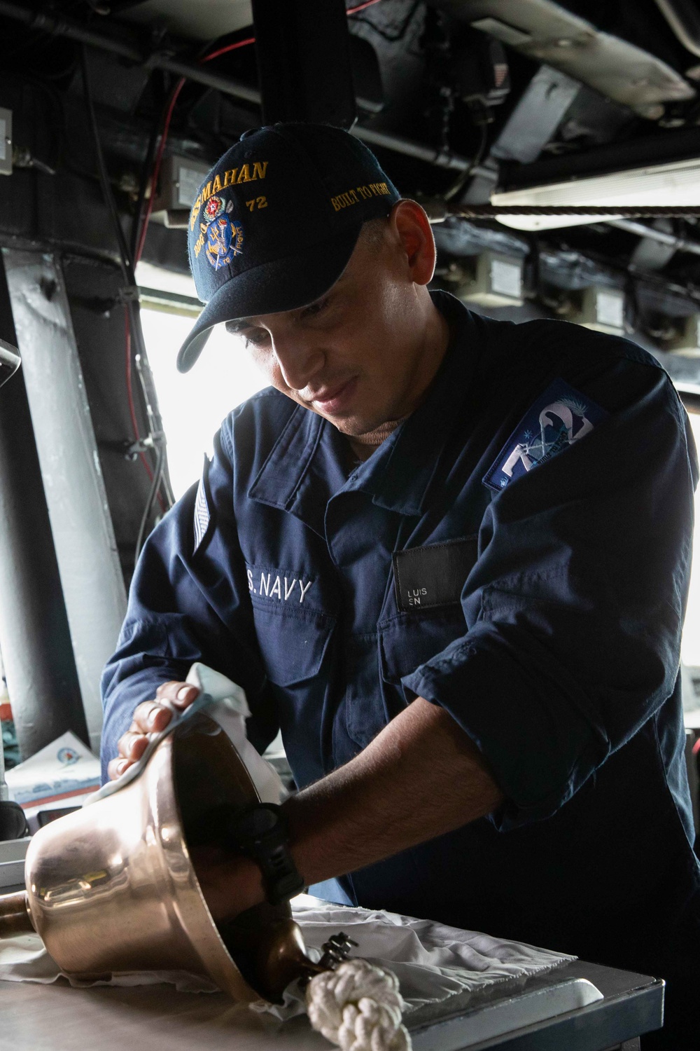 Boatswains Mate of the Watch Polishes Ships Bell