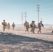 Marines sprint through the finish line during 1st Marine Division Squad Competition