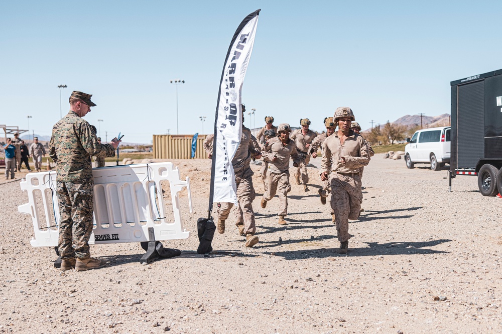 Marines sprint through the finish line during 1st Marine Division Squad Competition