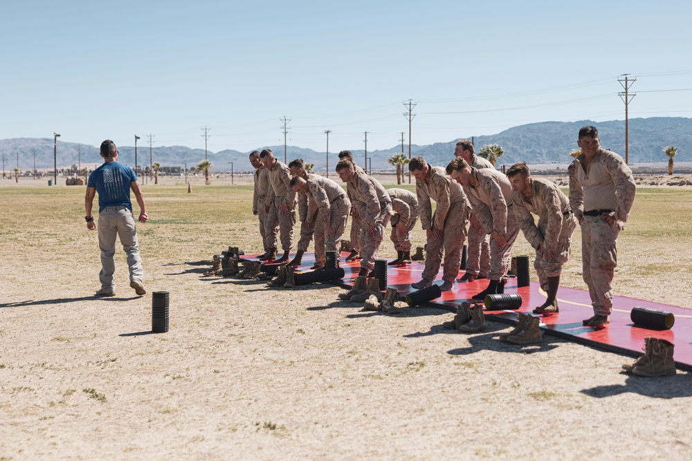 Marines sprint through the finish line during 1st Marine Division Squad Competition