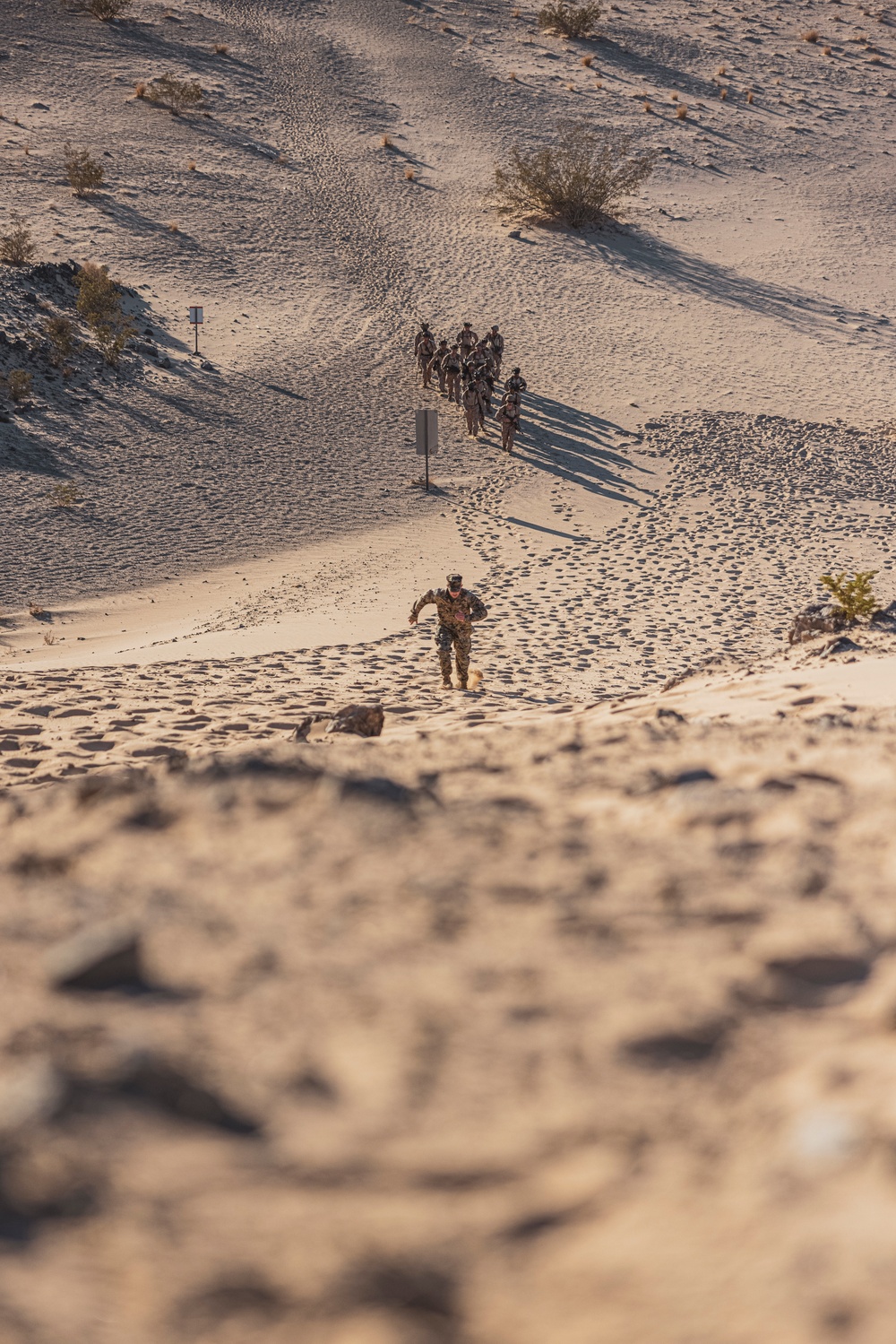 Marines sprint through the finish line during 1st Marine Division Squad Competition