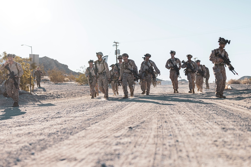 Marines sprint through the finish line during 1st Marine Division Squad Competition