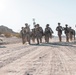 Marines sprint through the finish line during 1st Marine Division Squad Competition
