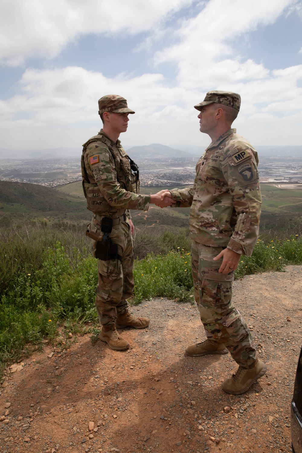 Leadership presents  a coin to soldier supporting southern border mission
