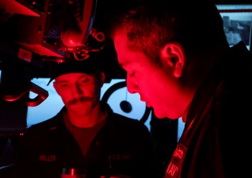Commanding officer of the USS Bulkeley (DDG 84) reviews log books with Ensign Conner Miller.