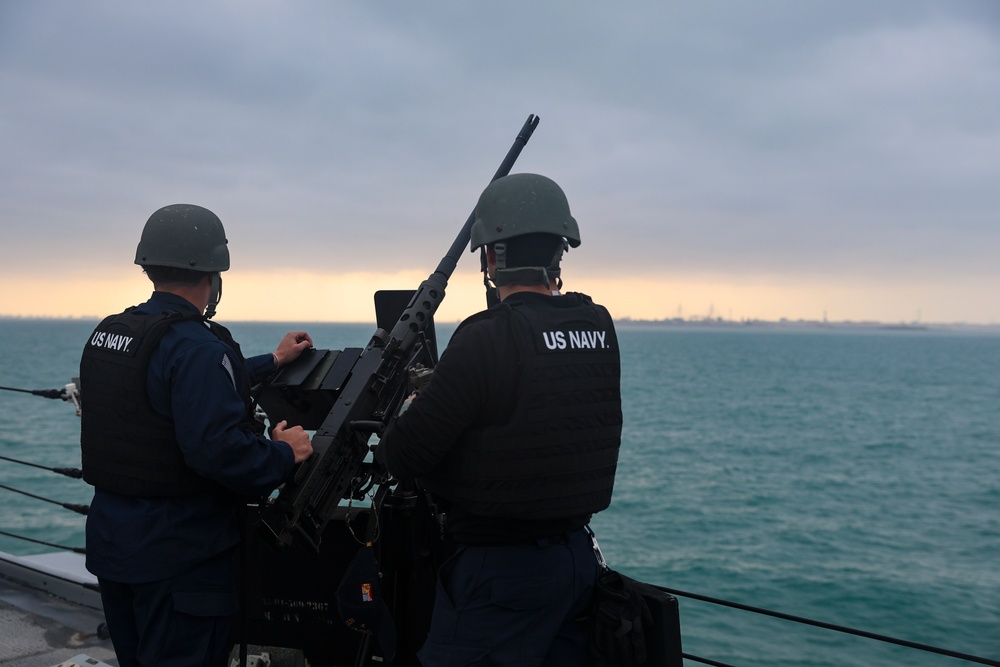 U.S. Navy Sailors stand watch at the starboard .50-Caliber machine gun mount.