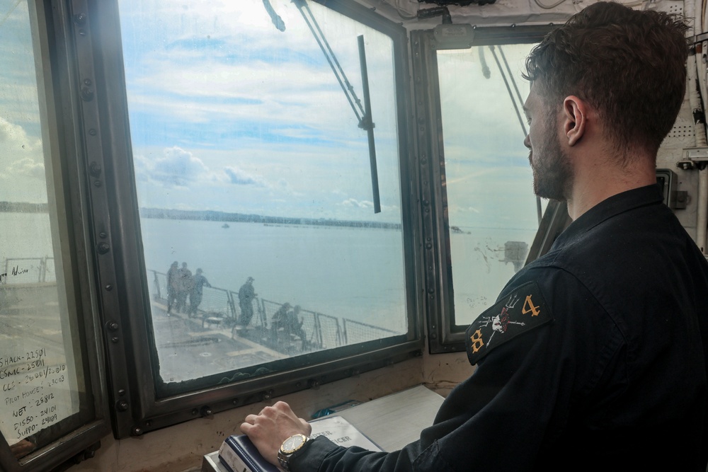 U.S. Navy Sailor observes a sea-and-anchor detail from the helicopter control tower