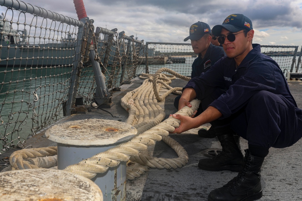U.S. Navy Sailors heave in mooring lines during a sea-and-anchor detail
