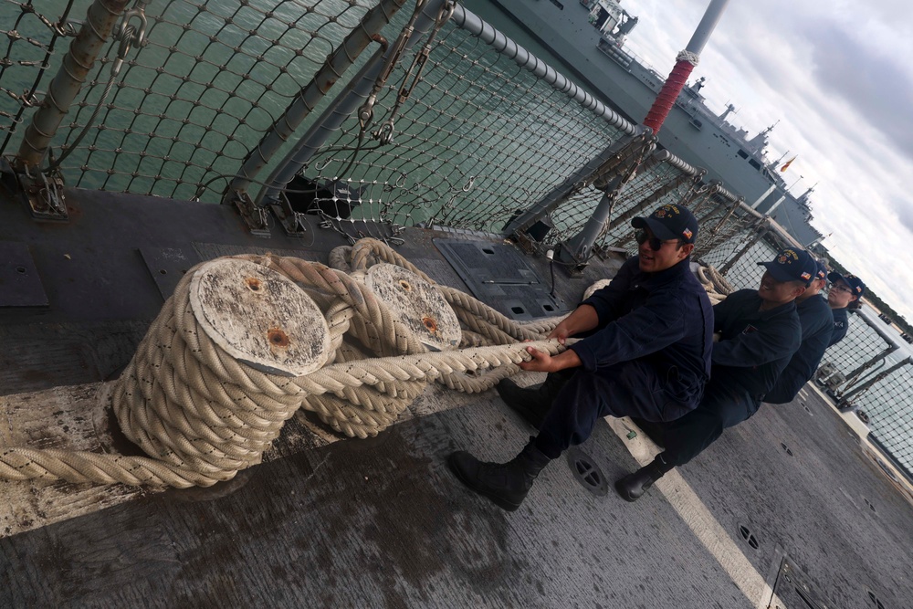 U.S. Navy Sailors heave in mooring lines during a sea-and-anchor detail