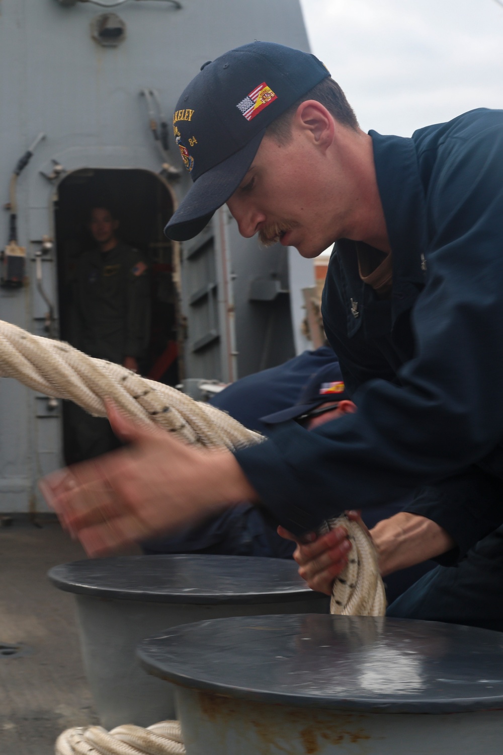 U.S. Navy Sailor heaves in mooring lines during a sea-and-anchor detail