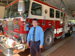 Ken Kajihiro stands in front of a fire truck