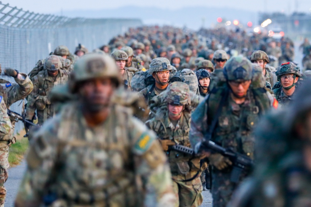 U.S Army Soldiers and ROK army soldiers complete a 12-mile ruck march during Expert Infantry, Soldier, Field Medical Badge testing.