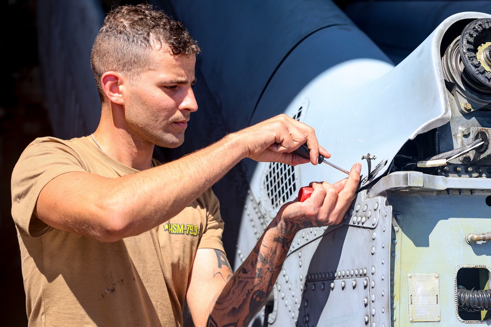 U.S. Navy Sailor installs fasteners on a MH-60R Sea Hawk helicopter