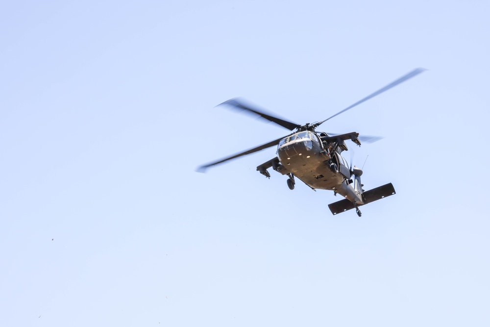 A Crewmember waves out of a UH-60 BlackHawk