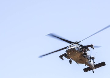 A Crewmember waves out of a UH-60 BlackHawk