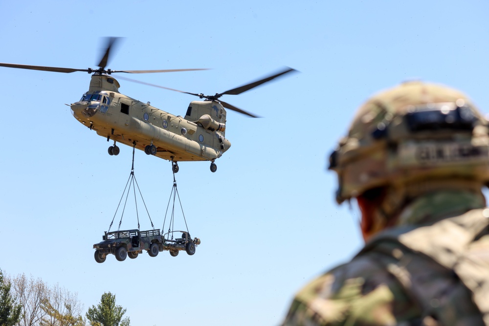 A CH-47 Chinook transports a Vehicle &amp; Weapon System
