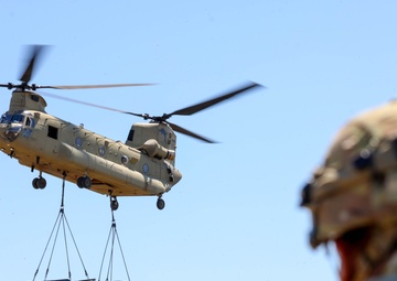 A CH-47 Chinook transports a Vehicle &amp; Weapon System