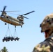 A CH-47 Chinook transports a Vehicle &amp; Weapon System