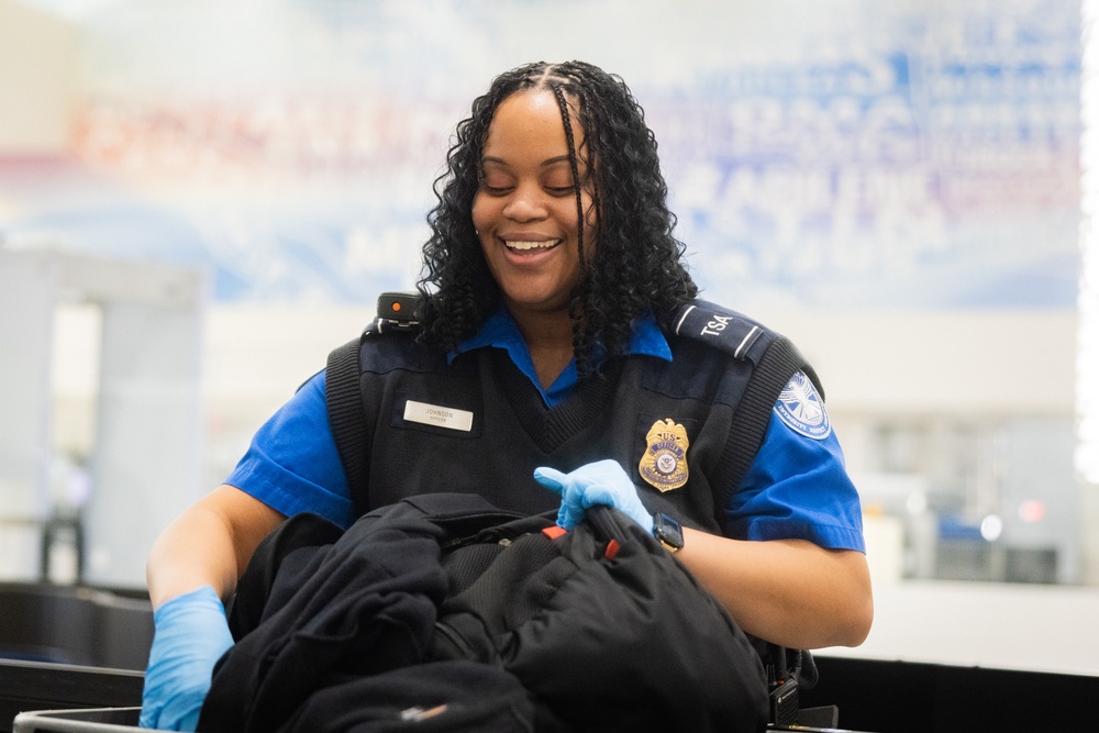 Officer screening passengers at a TSA checkpoint