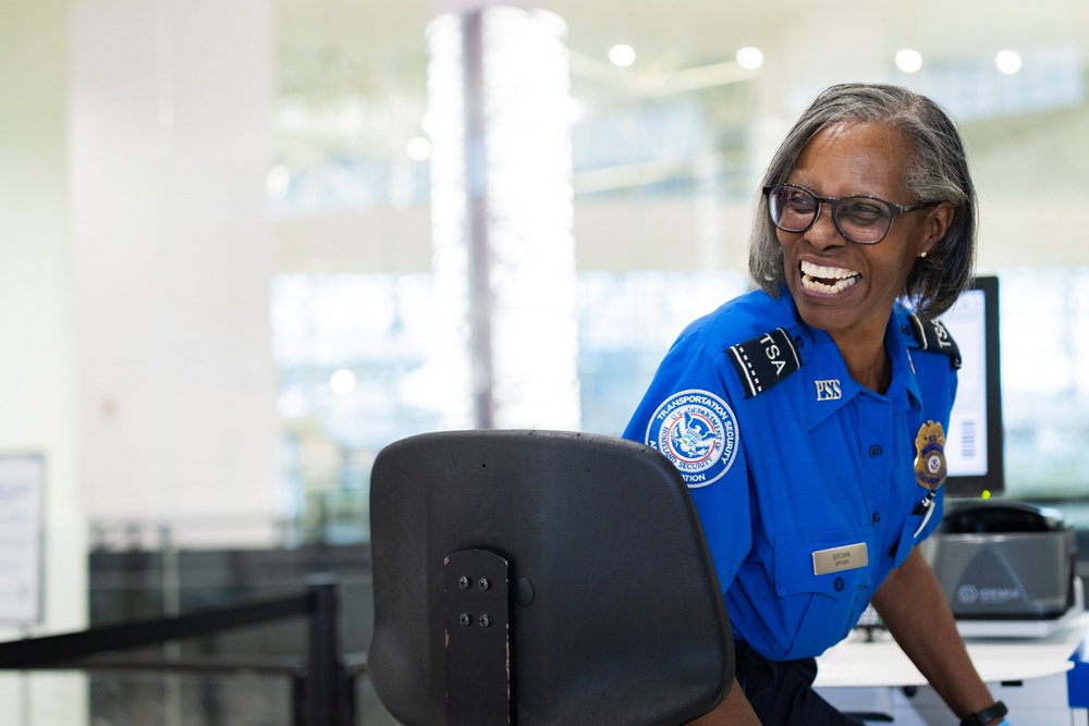 Officer screening passengers at a TSA checkpoint