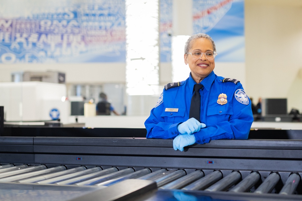 Officer screening passengers at a TSA checkpoint