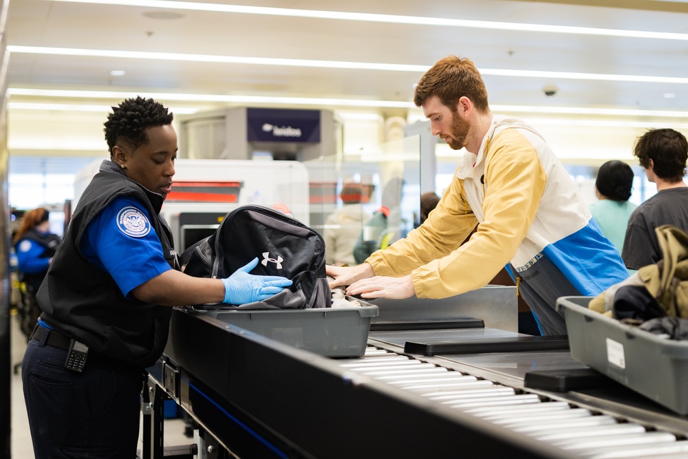 Officer screening passengers at a TSA checkpoint
