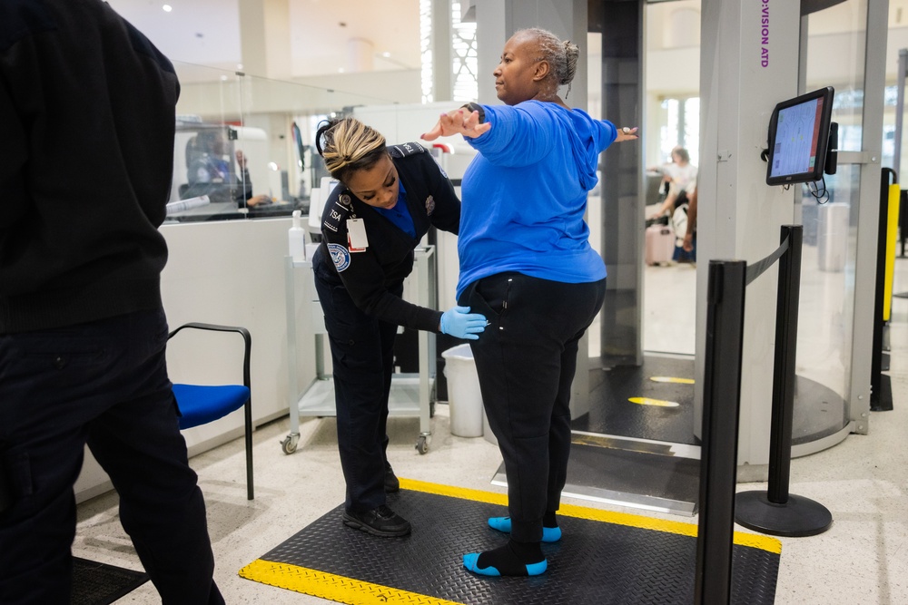 Officer screening passengers at a TSA checkpoint