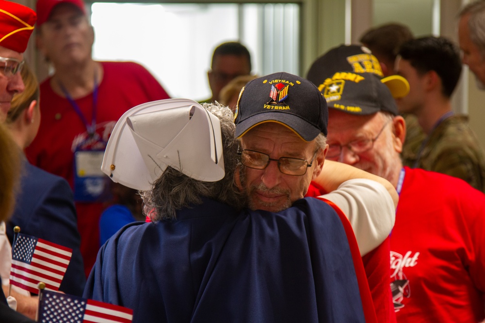 A nurse hugs a vietnam veteran returning from a honor flight