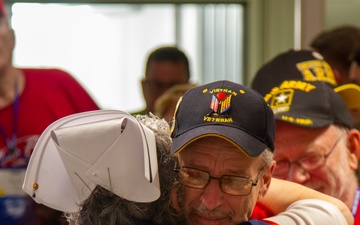 A nurse hugs a vietnam veteran returning from a honor flight