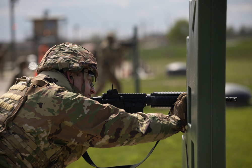 U.S. Army Sgt. Derek Combs, 350th Public Affairs Detachment, aims his M4