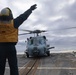 Boatswain Mate 2nd Class Jalynn Simons signals to the MH-60R Sea Hawk helicopter pilots