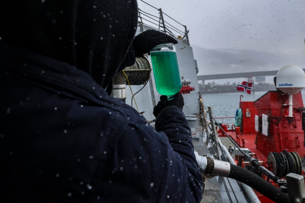 Gas Turbine Systems Technician 2nd Class Robert Capps inspects fuel for contaminants during a replenishment