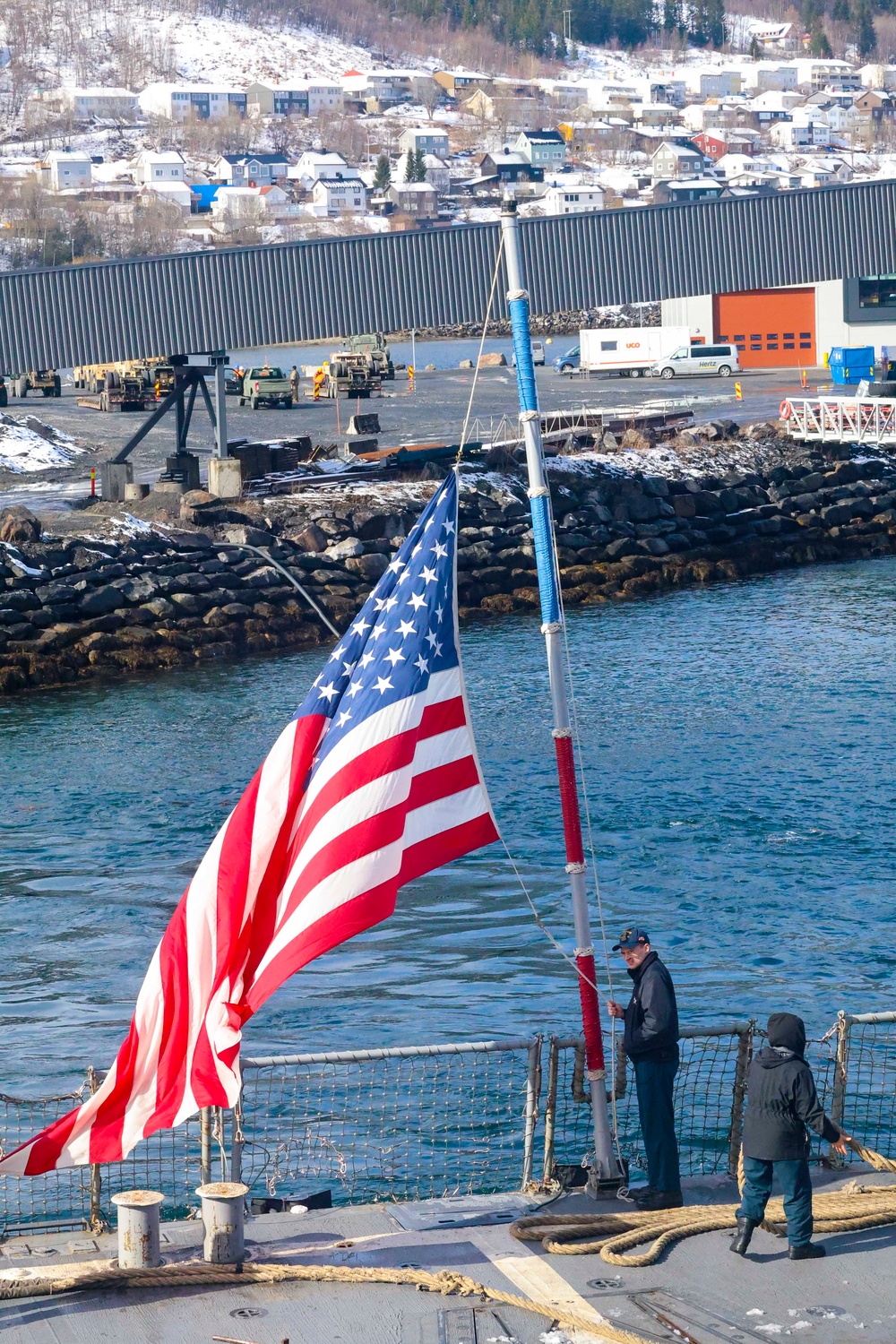 U.S. Navy Sailor brings down the ensign during a sea-and-anchor detail