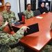Rear Adm. James Waters, Commander, Navy Recruiting Command, shows officer recruiters, assigned to Navy Talent Acquisition Group Ohio River Valley, a new trifold monitor configuration for government-issued laptops