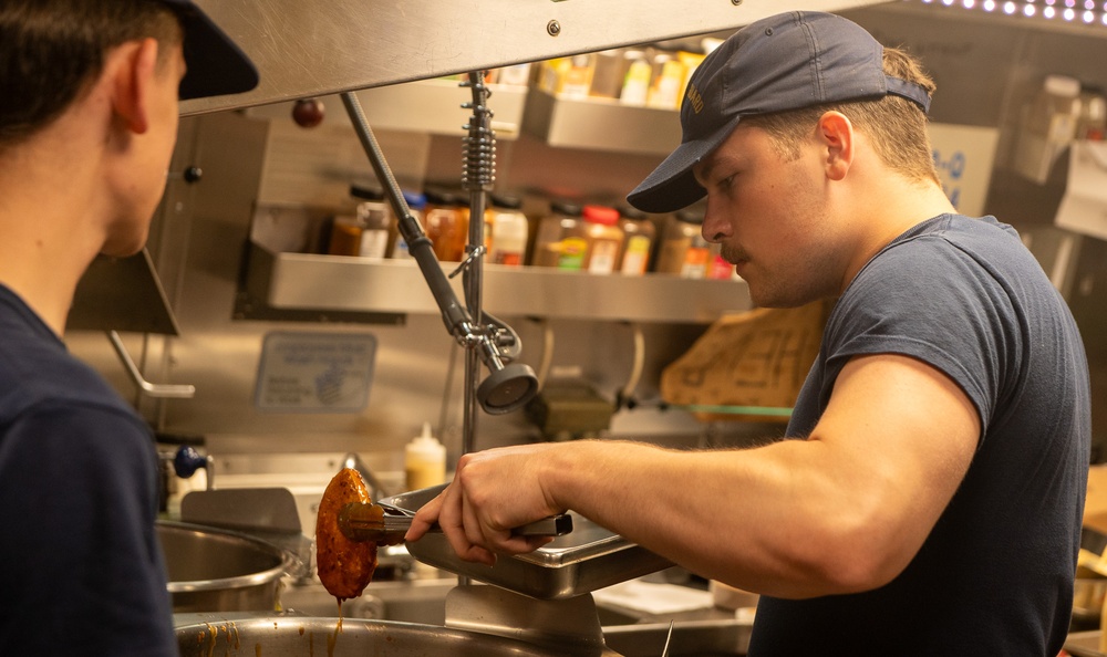 U.S. Coast Guard Cutter Stratton culinary specialists prepare lunch while transiting on the Pacific Ocean