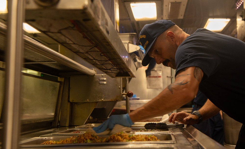 U.S. Coast Guard Cutter Stratton culinary specialists prepare lunch while transiting on the Pacific Ocean