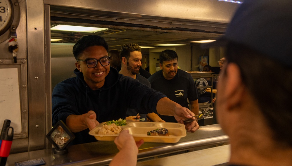 U.S. Coast Guard Cutter Stratton culinary specialists prepare lunch while transiting on the Pacific Ocean