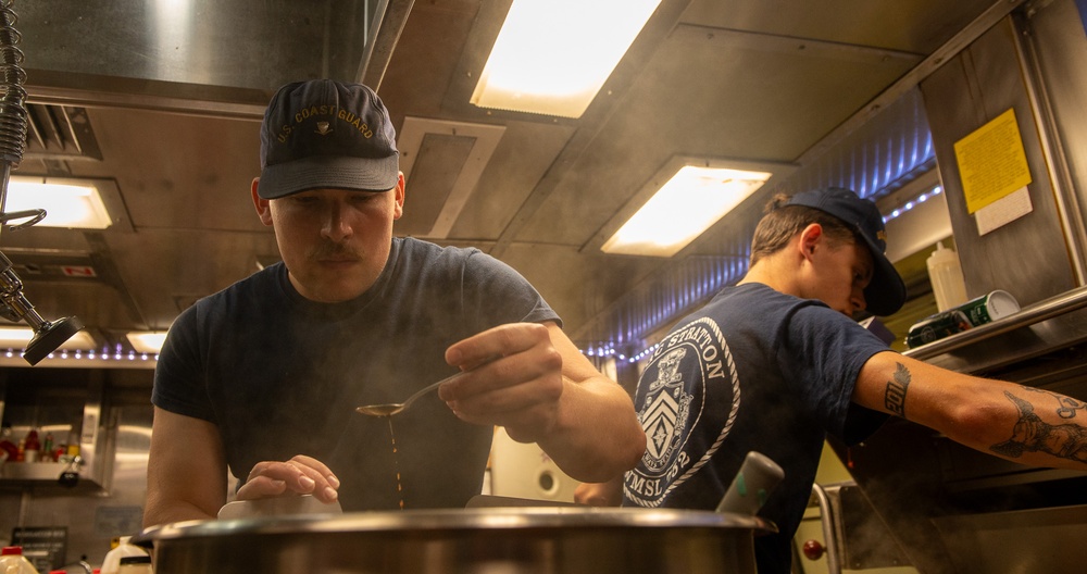U.S. Coast Guard Cutter Stratton culinary specialists prepare lunch while transiting on the Pacific Ocean