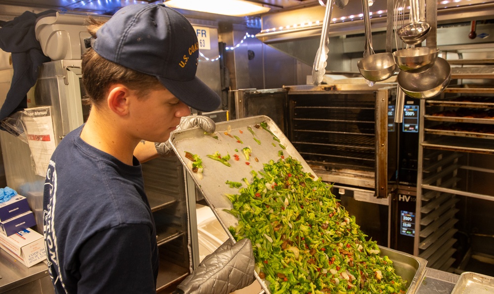 U.S. Coast Guard Cutter Stratton culinary specialists prepare lunch while transiting on the Pacific Ocean