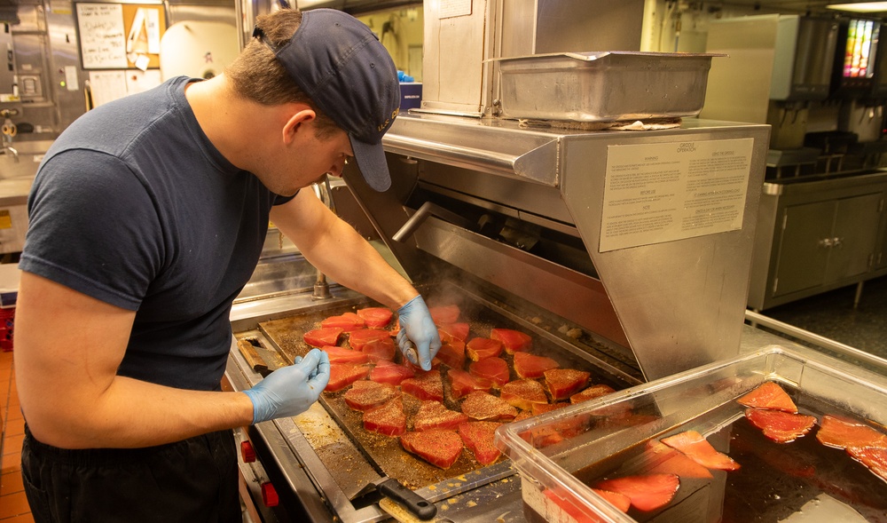 U.S. Coast Guard Cutter Stratton culinary specialists prepare lunch while transiting on the Pacific Ocean
