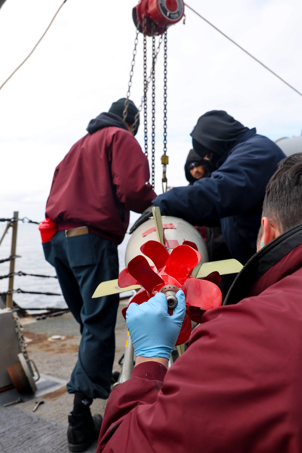 U.S. Navy Sailors hoist a torpedo into its launcher during Formidable Shield (FS) 2025