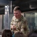 Security Forces member demonstrates the weight of the plate carrier to children during a base tour at the Nevada Air National Guard Base
