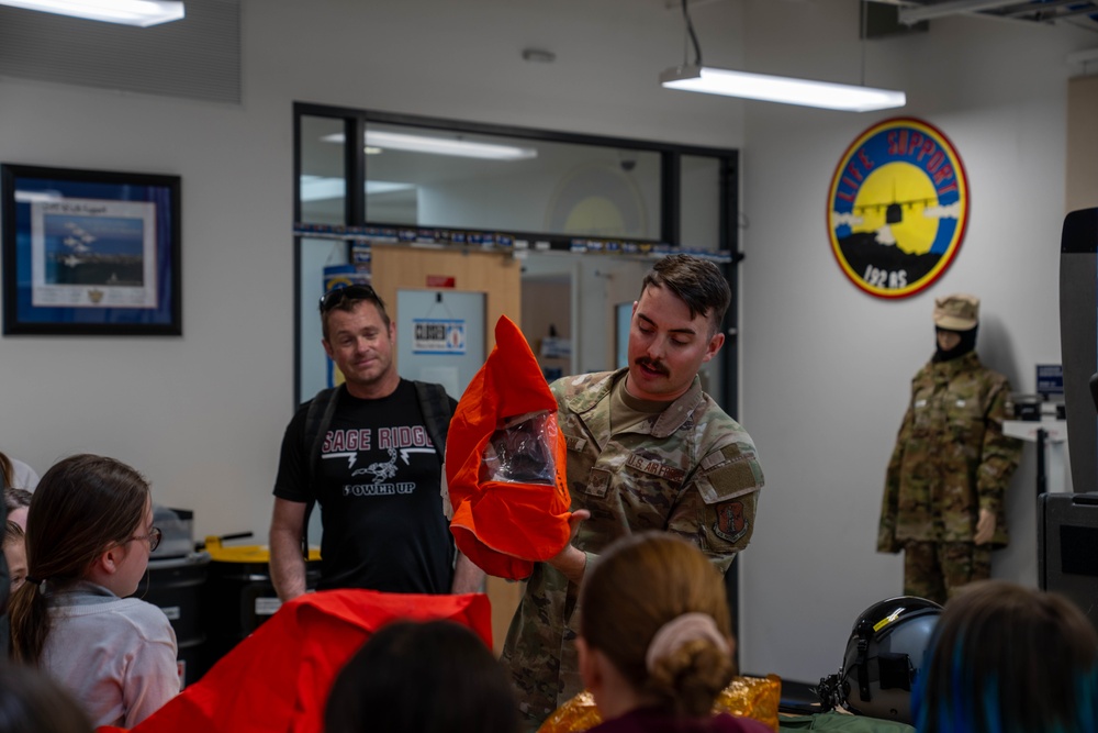 Staff Sgt. Kyle Sampson, assigned to the 152nd Operations Support Squadron, demonstrates the use of safety equipment to children during a base tour at the Nevada Air National Guard Base on May 9, 2025