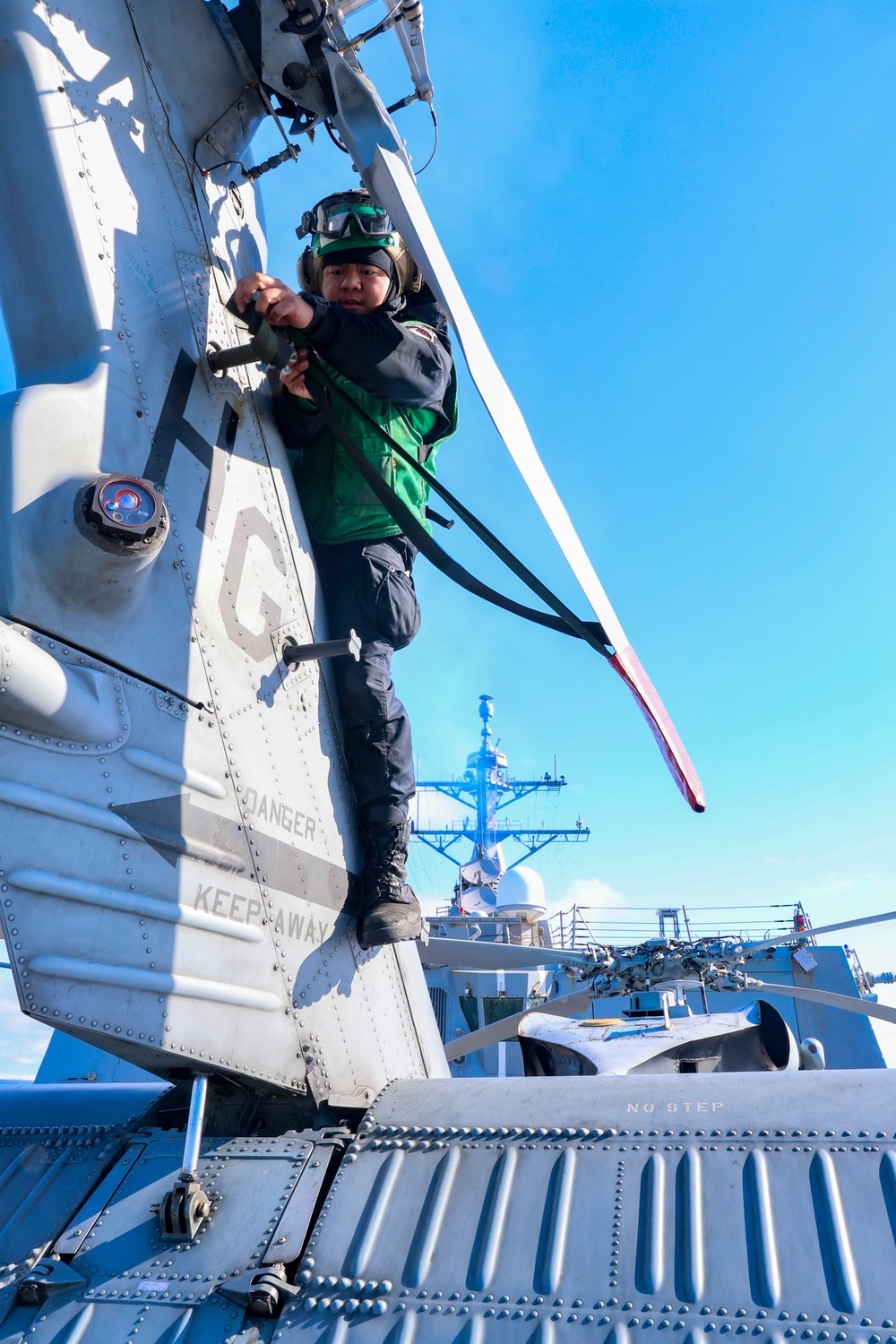 Aviation Machinist’s Mate 2nd Class Keith Gonzales  installs a tail rotor blade cover on a MH-60R Sea Hawk helicopter