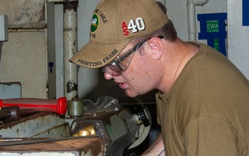 USS Frank Cable Sailor lathing in machine shop