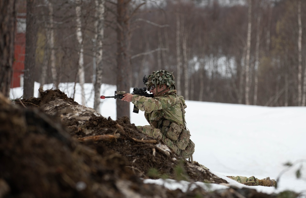 A Paratrooper from the 2nd Battalion, 505th Parachute Infantry Regiment, 3rd Brigade Combat Team, 82nd Airborne Division pulls security from behind cover, May 15, 2025 in Setermoen, Norway.