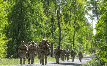 Competitors complete ruck march during V Corps Best Squad Competition