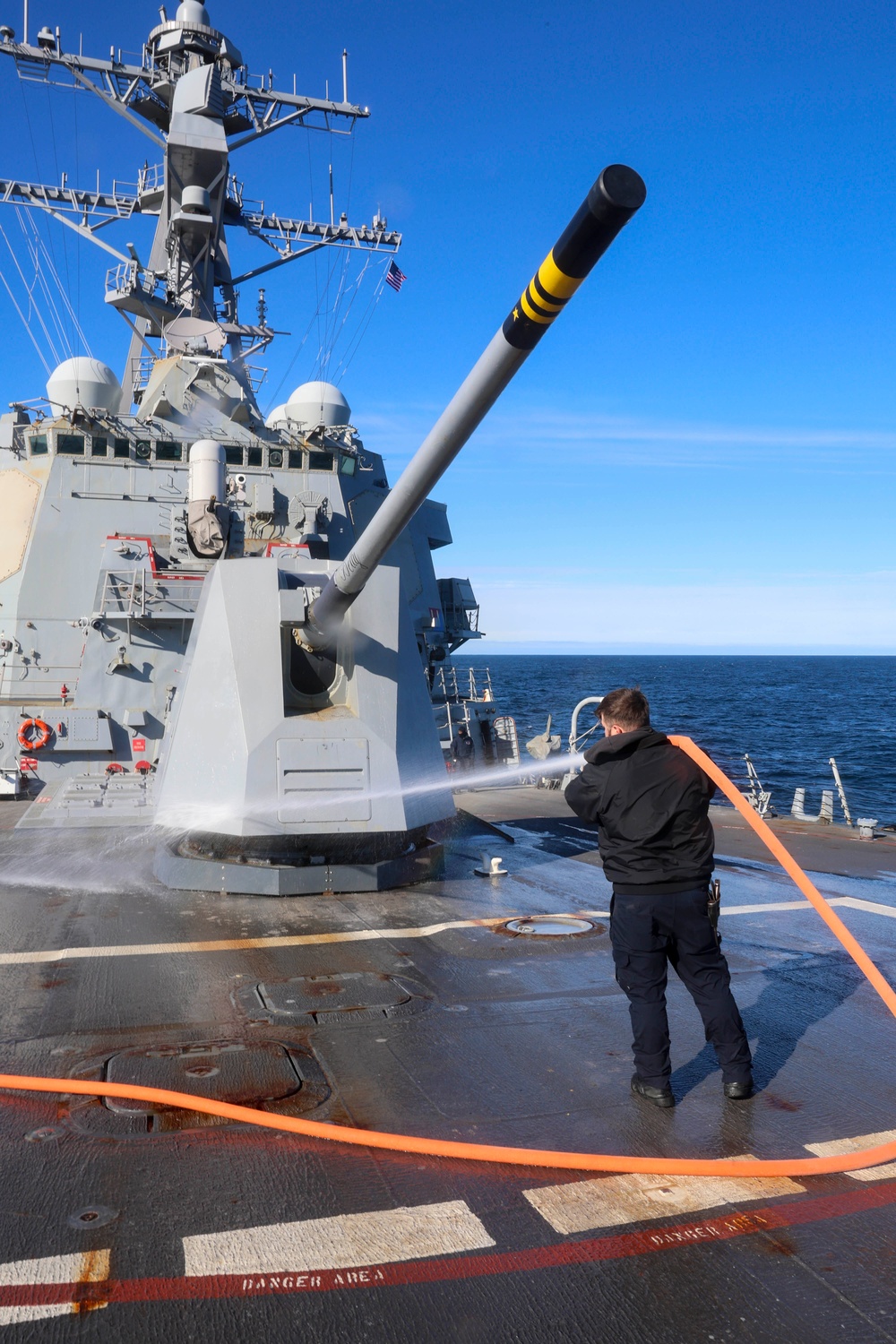 Boatswain’s Mate 1st Class Ethan Elks conduct a fresh water wash down on the fo’c’sle