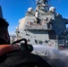 Boatswain’s Mate 1st Class Ethan Elks conducts a fresh water wash down on the fo’c’sle