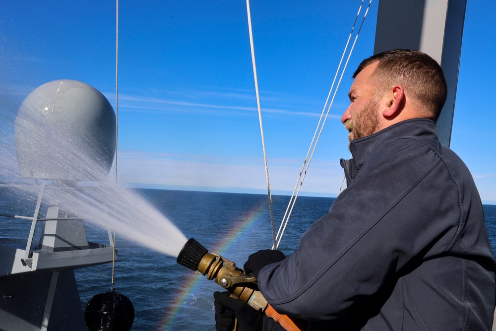 Electrician’s Mate 1st Class Kyle Allen conducts a fresh water wash down on the USS Bulkeley